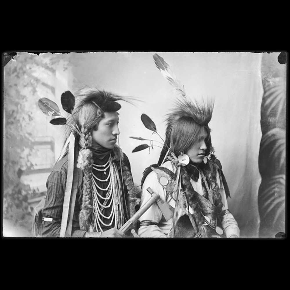 Photograph of two men from Northern Shoshone or Bannock tribe in traditional dress.