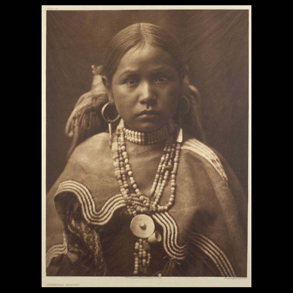 Photograph of young Native American girl of the Jicarilla tribe in traditional dress.