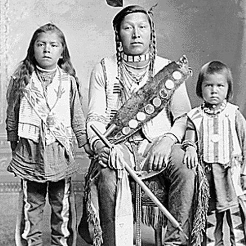 Photograph of an adult and two children of the Northern Shoshone tribe in traditional dress