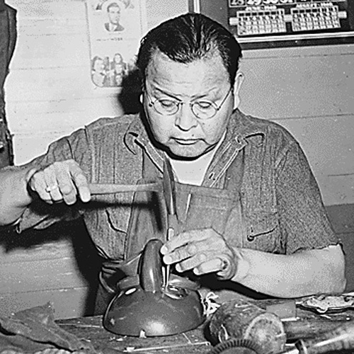 Photograph of Native American man carving a ceremonial mask